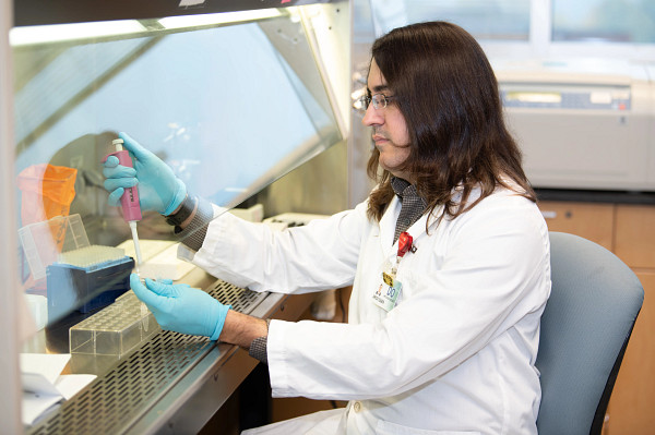 Lyme disease researcher in lab using equipment.