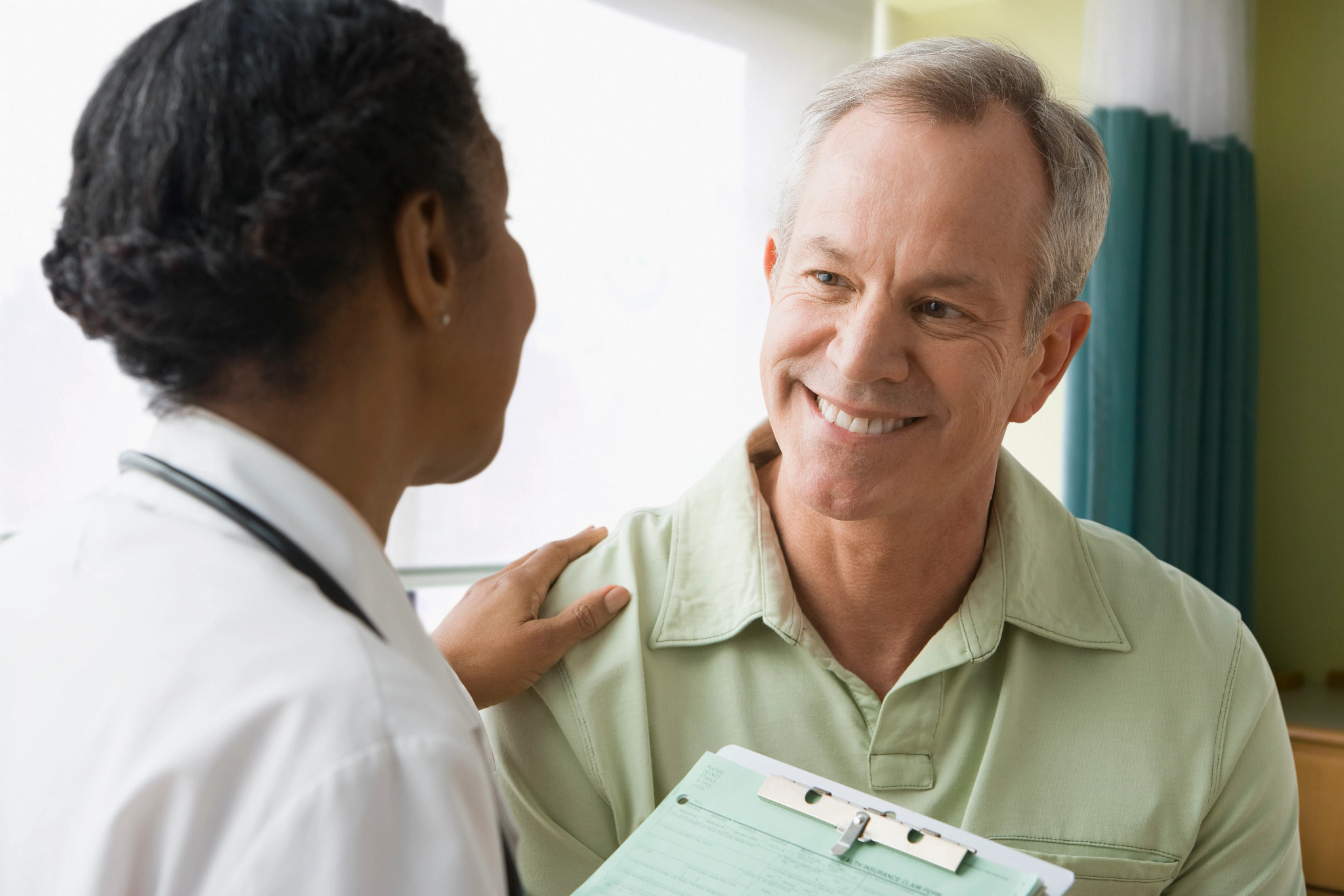 Female doctor putting hand on male patient