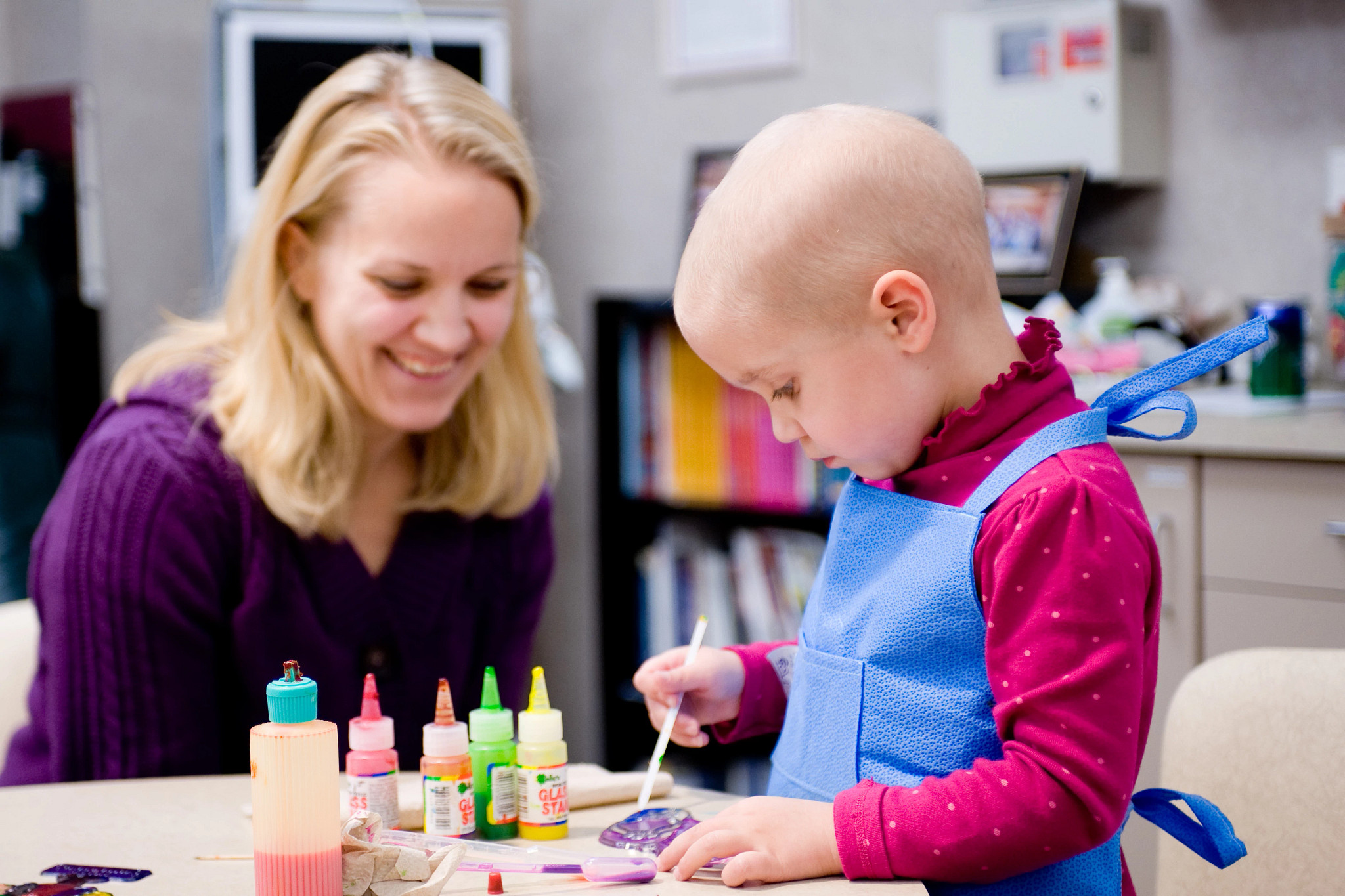 Mini apron made from recycled blue wrap surgical waste on pediatric oncology patient