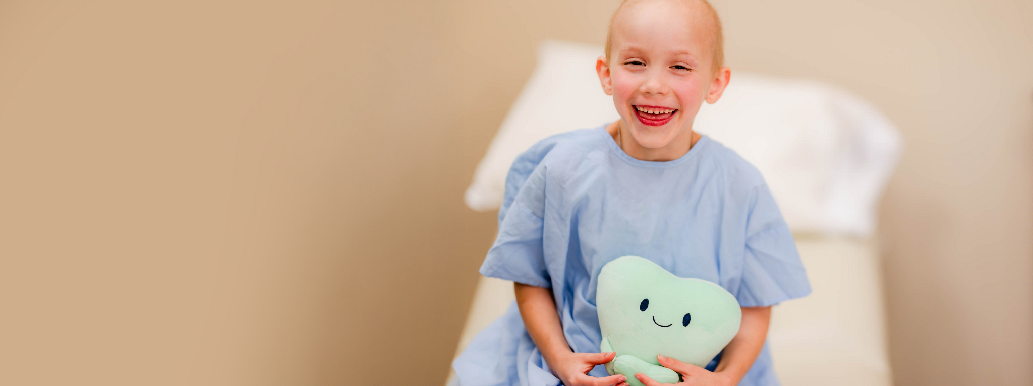 Young cancer patient holding a plush toy in the hospital