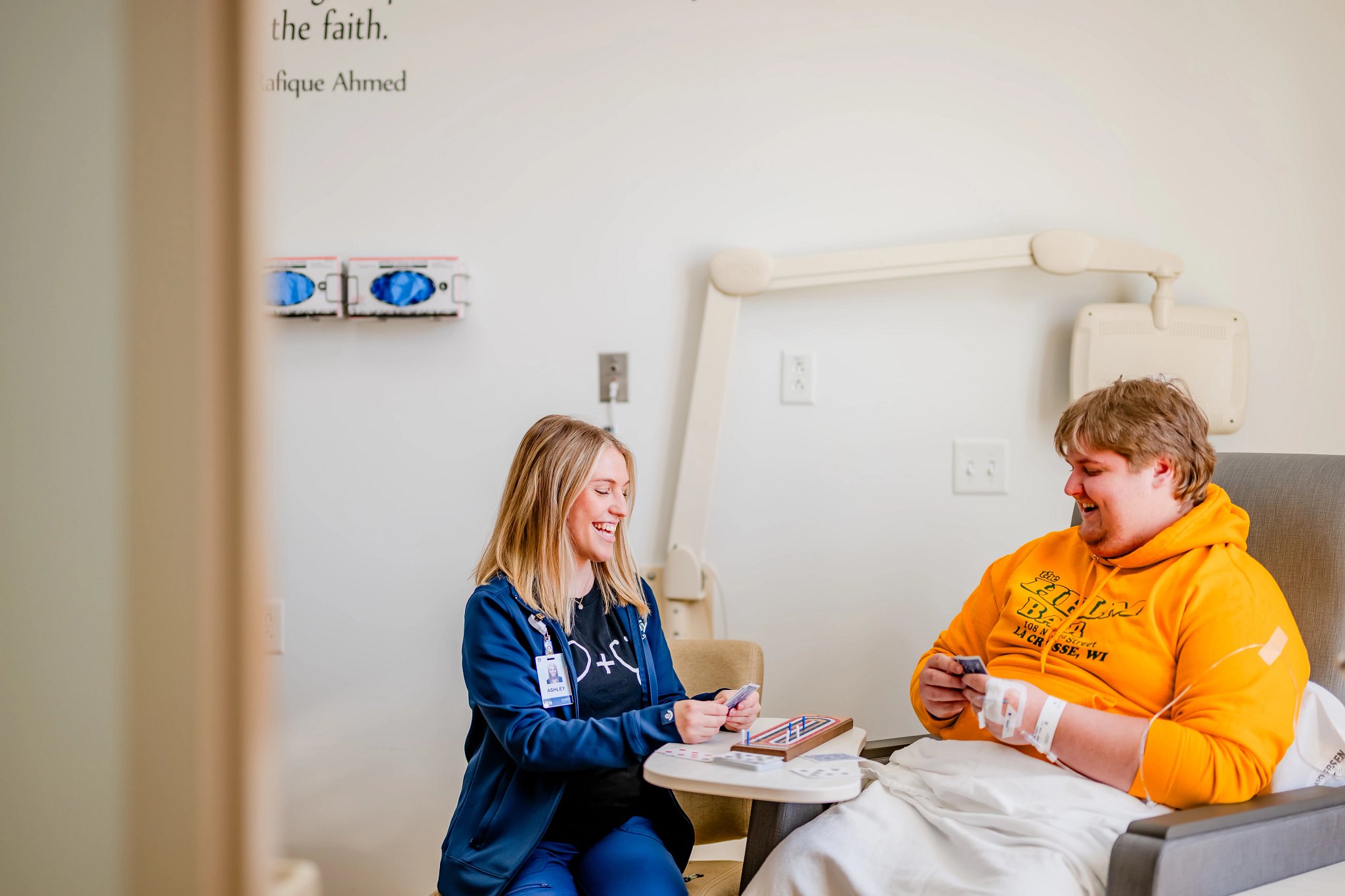 Female nurse playing a game with a male patient getting an infusion